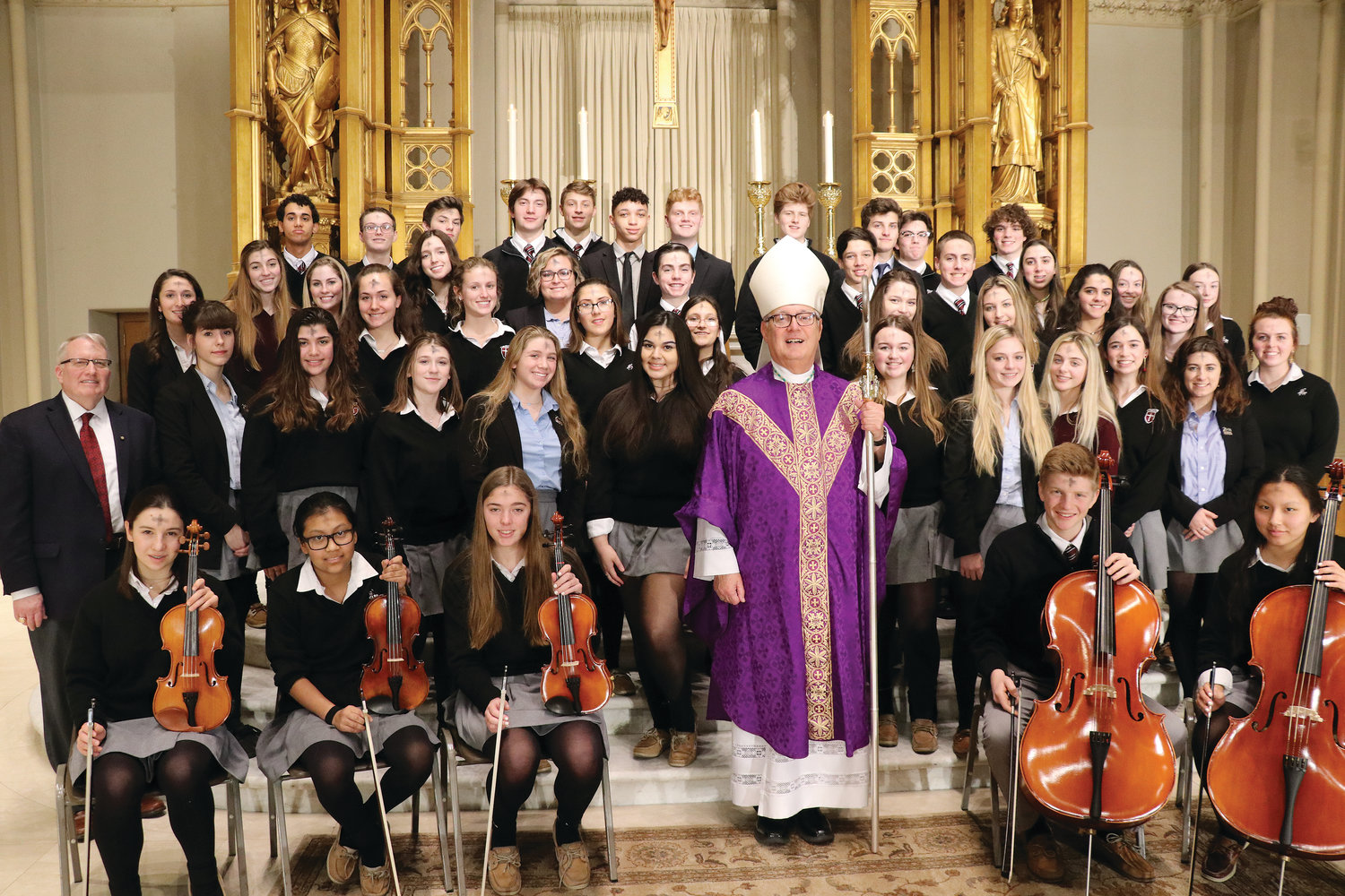Bishop Tobin smiles with The Prout School Choir.